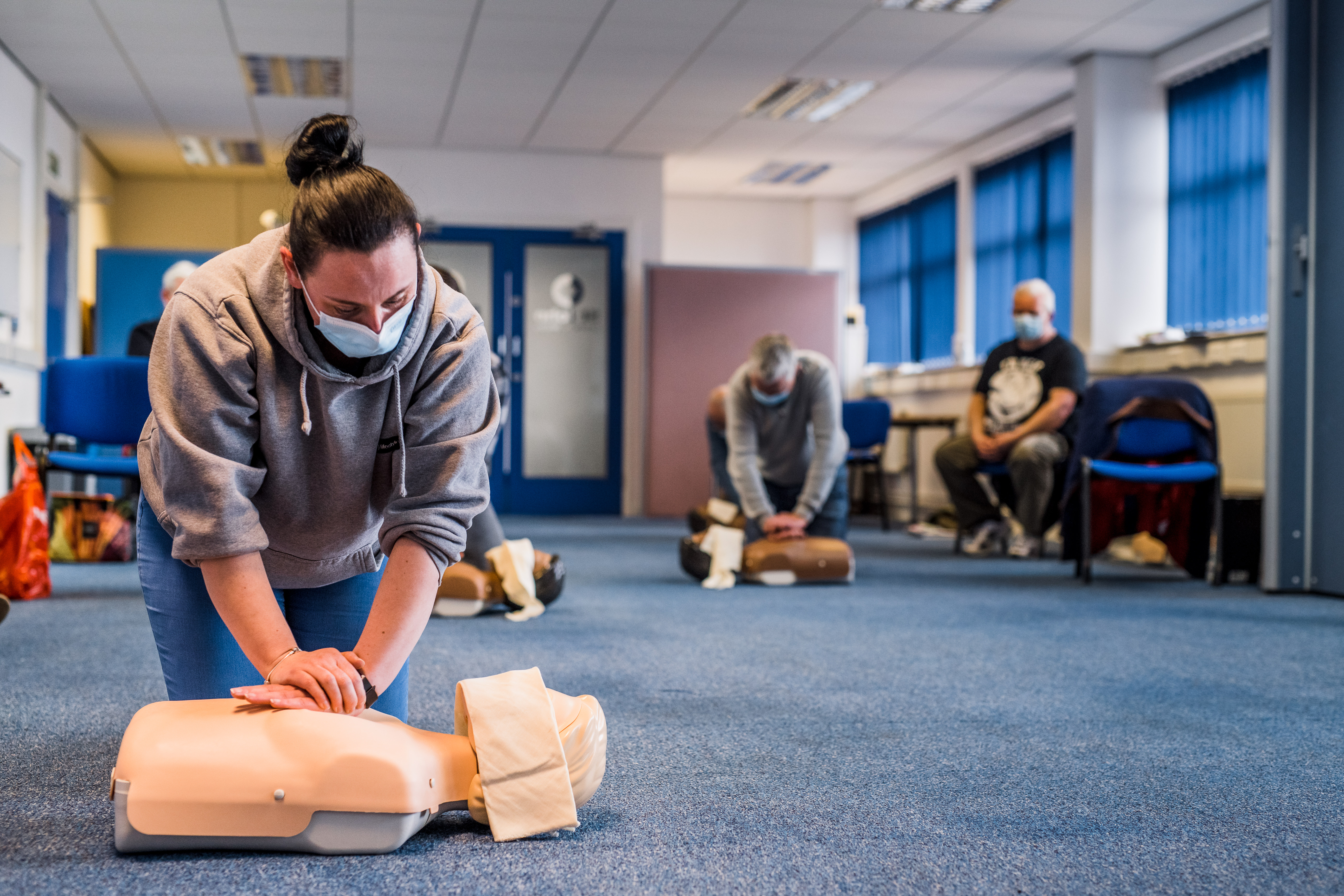 what is emergency first aid at work? a woman practicing cpr